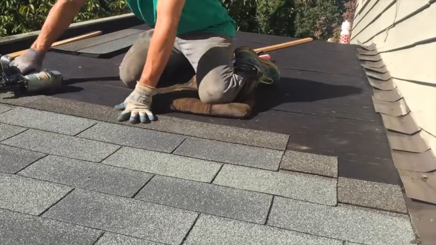 Man laying Roofing Shingles